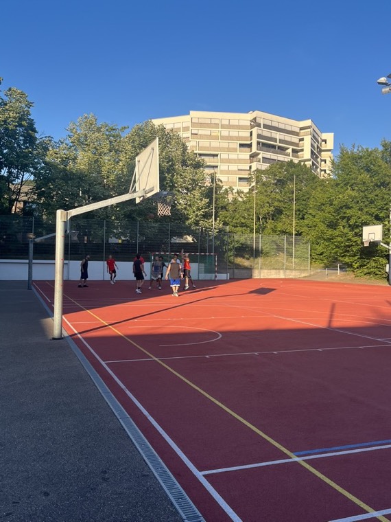 Pickup game on an outdoor court on a summer evening