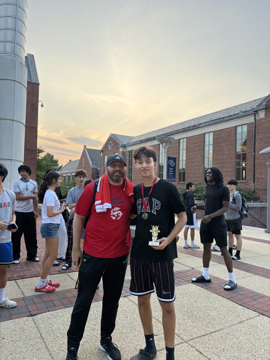 Vinicius holding the GOAT Award trophy next to Coach Tim Respass, Global Squad Summer Program 2026